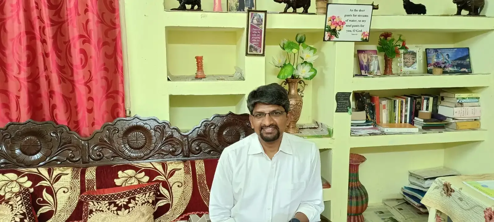 ವಾಸದ ಕೋಣೆಯ ಸೋಫಾದಲ್ಲಿ ಕುಳಿತಿರುವ ವ್ಯಕ್ತಿ.